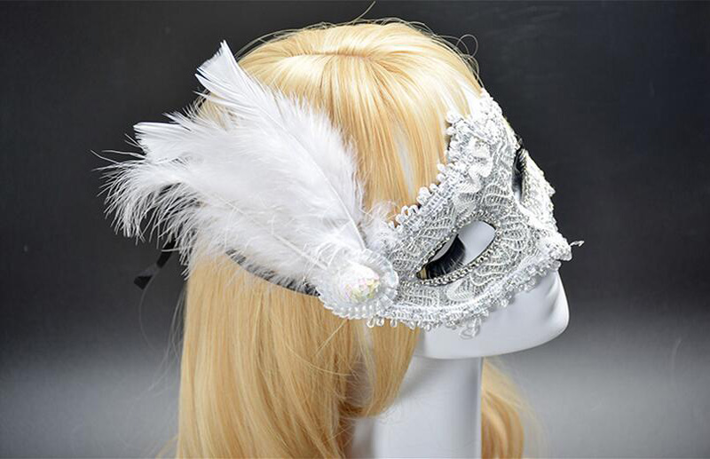 Masque vénitien blanc en dentelle avec plumes blanches sur le côté, décor baroque et strass, porté sur un mannequin blond