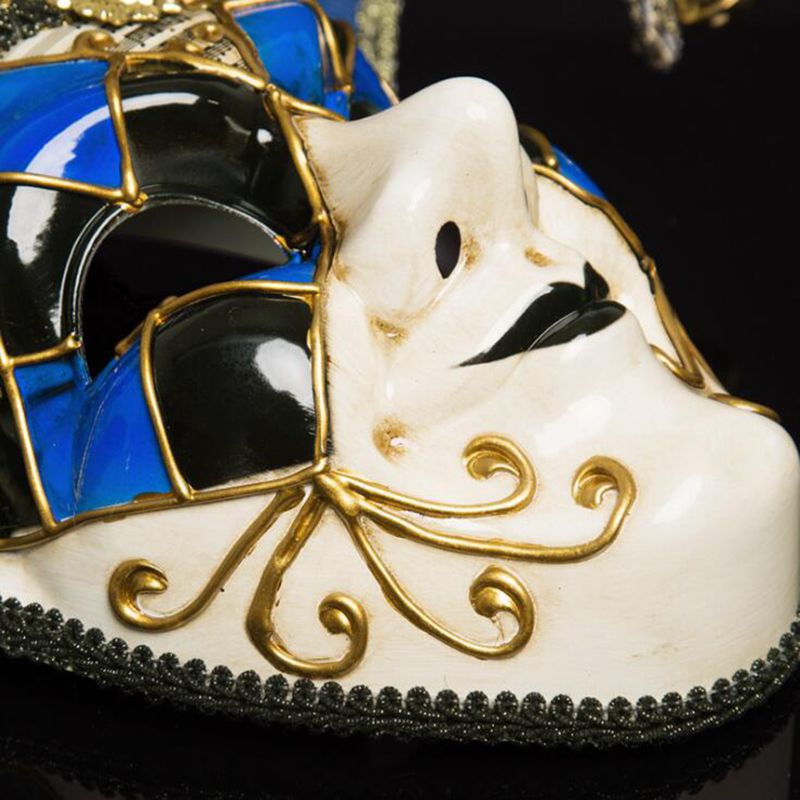 Détail du masque vénitien Joker en céramique blanc et bleu avec motifs noirs et dorés, bordure en dentelle noire