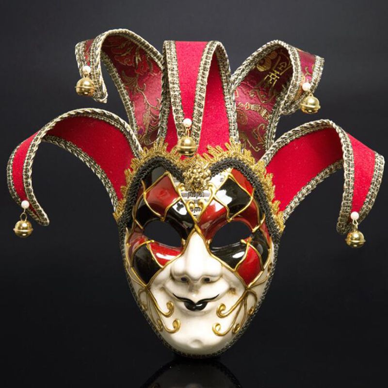 Masque vénitien Joker en céramique blanche avec motif losanges rouges et noirs, orné de bordures dorées et de clochettes sur les pointes en tissu rouge et noir