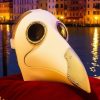 Masque blanc Commedia Dell’Arte Médecin de la Peste noir avec long bec, cerclage métallique doré autour des yeux, posé sur tissu rouge