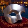 Masque carnaval de Venise argent demi-visage lisse avec forme asymétrique posé sur tissu rouge brodé
