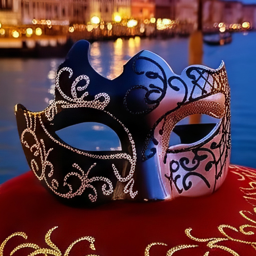 Masque loup vénitien bicolore noir et argent avec motifs baroques et strass, posé sur tissu rouge brodé, fond flou de lumière nocturne